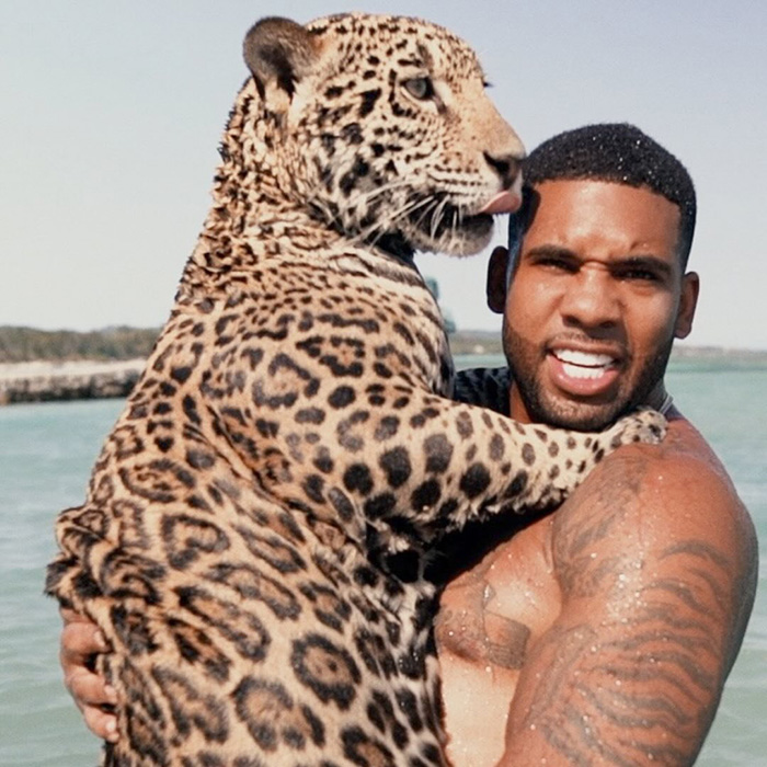 Man holding a large jaguar by the water, unrelated to Jurassic World star BD Wong apology over racist comment. Man holding a large jaguar by the water, unrelated to Jurassic World star BD Wong apology over racist comment.