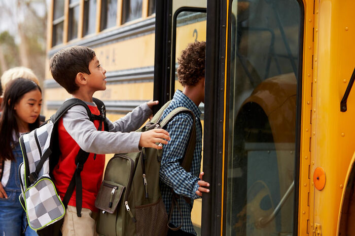 Children boarding a school bus, illustrating a moment in stories about revenge that left a bitter aftertaste.