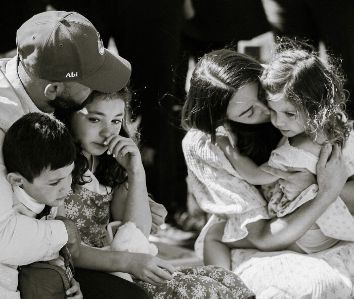 Family grieving together, mother comforting young daughter, reflecting the influencer's daughter's passing and family loss. Family grieving together, mother comforting young daughter, reflecting the influencer's daughter's passing and family loss.