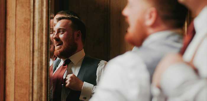 Groom adjusting tie and smiling nervously before wedding ceremony during couple split at altar unexpected revelations.
