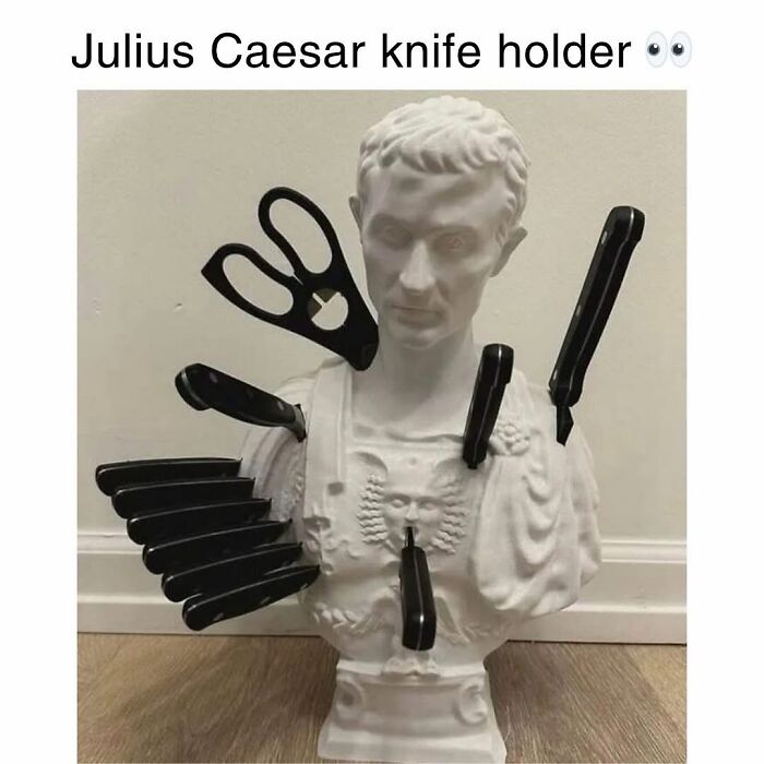 Bust of Julius Caesar used as a knife holder with multiple knives and scissors inserted, a funny movie meme concept.