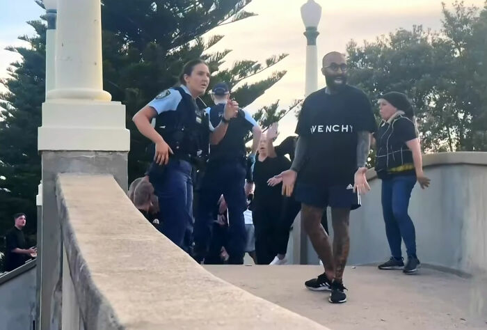 Police officers interacting with a man and crowd at Bondi Beach during an incident that sparked widespread outrage. Police officers interacting with a man and crowd at Bondi Beach during an incident that sparked widespread outrage.