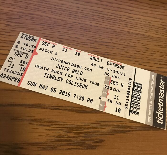 Concert tickets on a wooden table, illustrating crazy things people have done believing their ex will always pine for them.