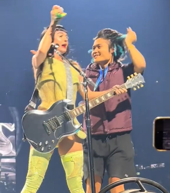 Lady Gaga performing on stage with guitar during concert, highlighting a jailed man’s trouble at the event.