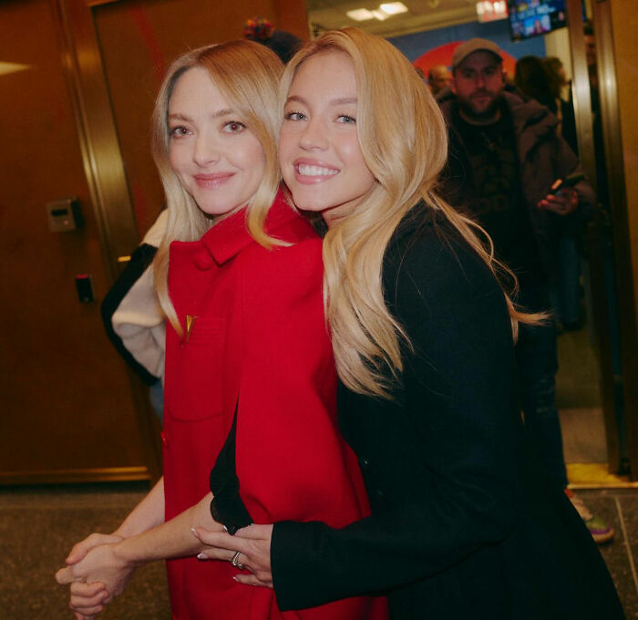 Two smiling women with blonde hair embrace indoors, relating to Sydney Sweeney and lie detector test controversy. Two smiling women with blonde hair embrace indoors, relating to Sydney Sweeney and lie detector test controversy.