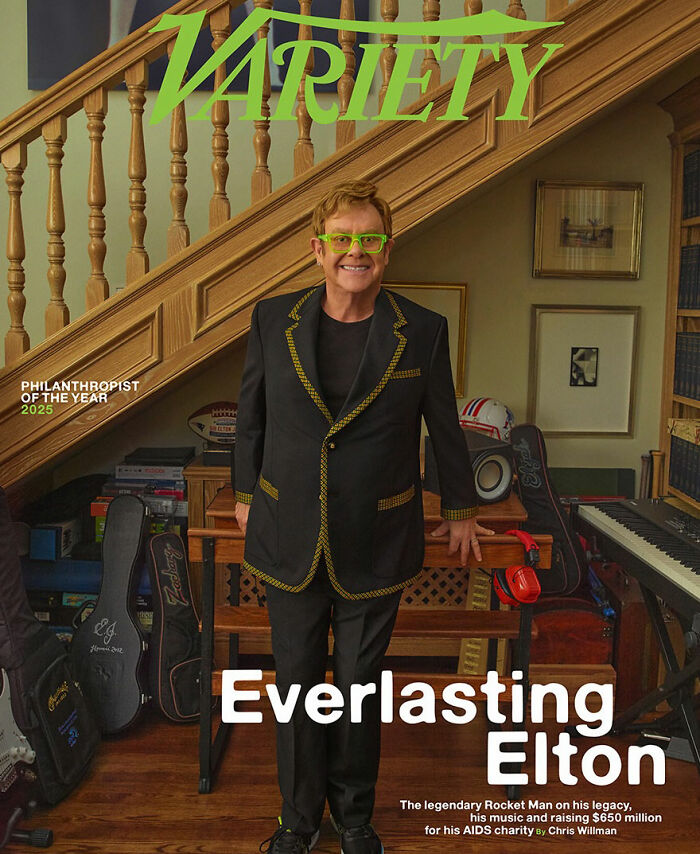 Elton John stands smiling indoors with musical instruments around, highlighting Elton John kitchen detail fans troll. Elton John stands smiling indoors with musical instruments around, highlighting Elton John kitchen detail fans troll.