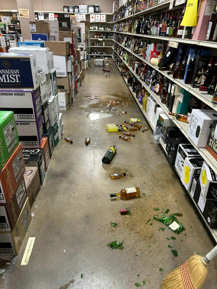 Liquor store aisle with broken bottles and spilled alcohol after a raccoon raid causes chaotic mess on the floor. Liquor store aisle with broken bottles and spilled alcohol after a raccoon raid causes chaotic mess on the floor.