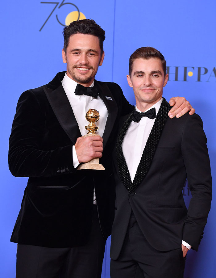 Two men in tuxedos at an awards event, one holding a trophy, representing James Franco and Hollywood insights.