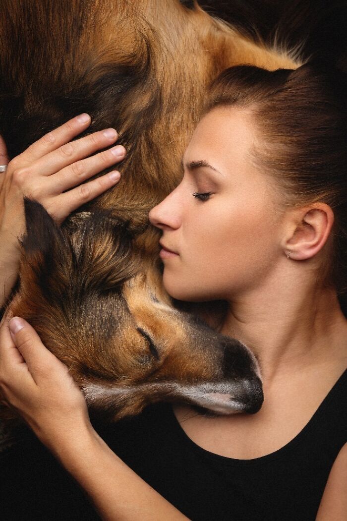 Close-up of a woman lovingly embracing a calm dog, showcasing one of the best dog photos in the world.