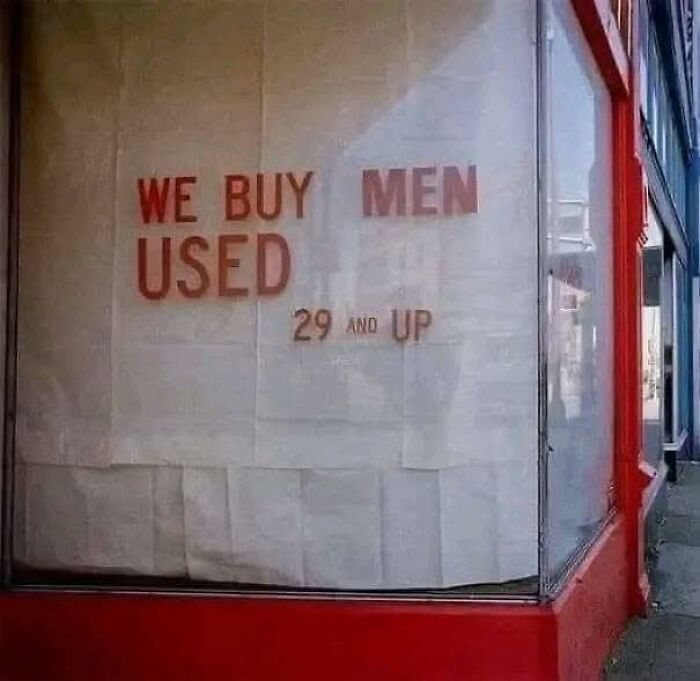 Sign on window reading we buy used men 29 and up, a funny meme for dark and cold winter days humor.