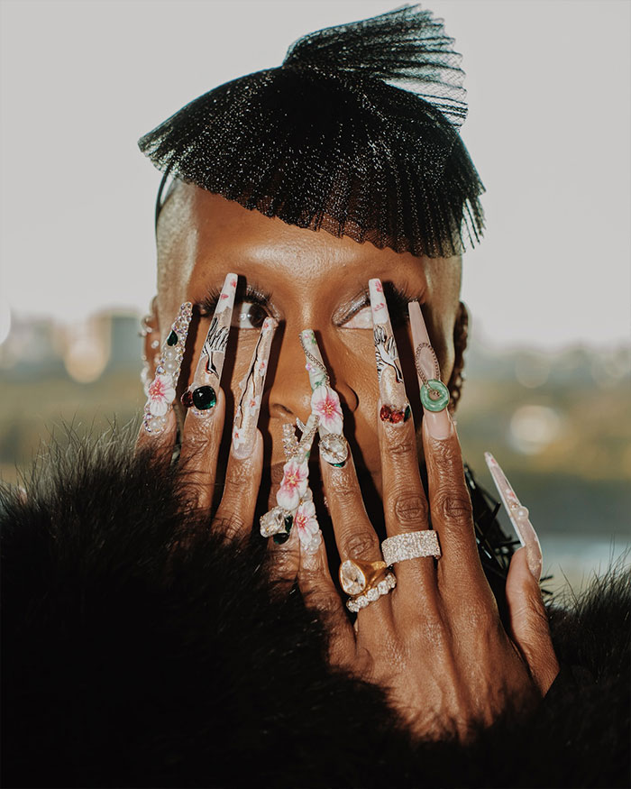 Cynthia Erivo showing off oddly large hands with long floral nails and rings, sparking fashion and beauty debate. Cynthia Erivo showing off oddly large hands with long floral nails and rings, sparking fashion and beauty debate.