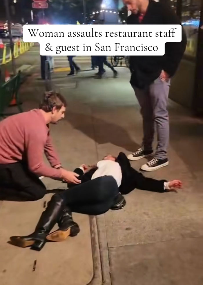 Woman lying on sidewalk after drunken rampage at upscale restaurant, helped by bystanders in urban night scene. Woman lying on sidewalk after drunken rampage at upscale restaurant, helped by bystanders in urban night scene.