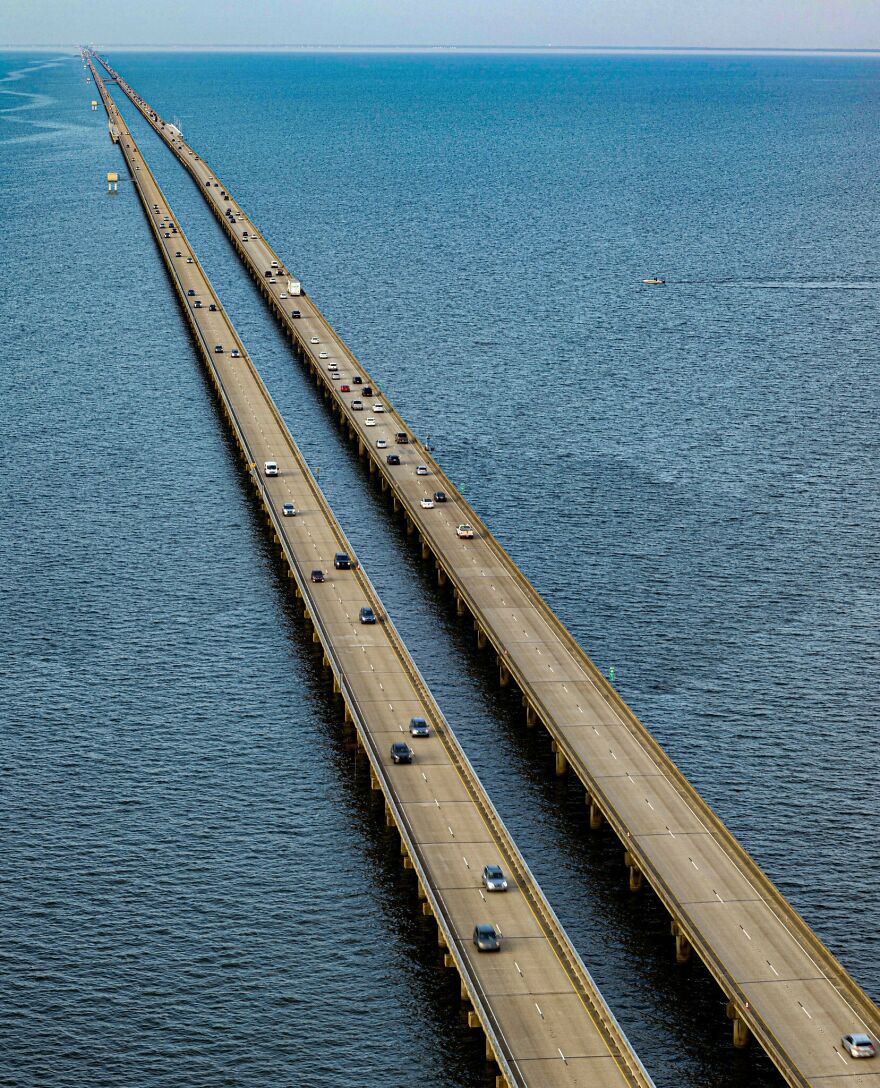 Aerial view of two long bridges over water with multiple cars showcasing remarkable engineering of longest bridges.