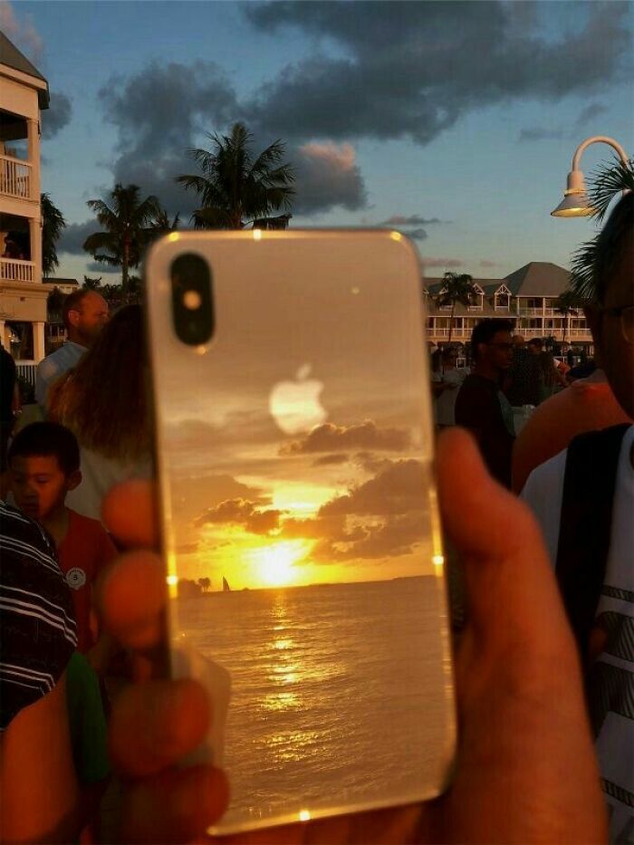 Reflection of a sunset on an iPhone back creating a trippy picture that seems plucked from another reality.