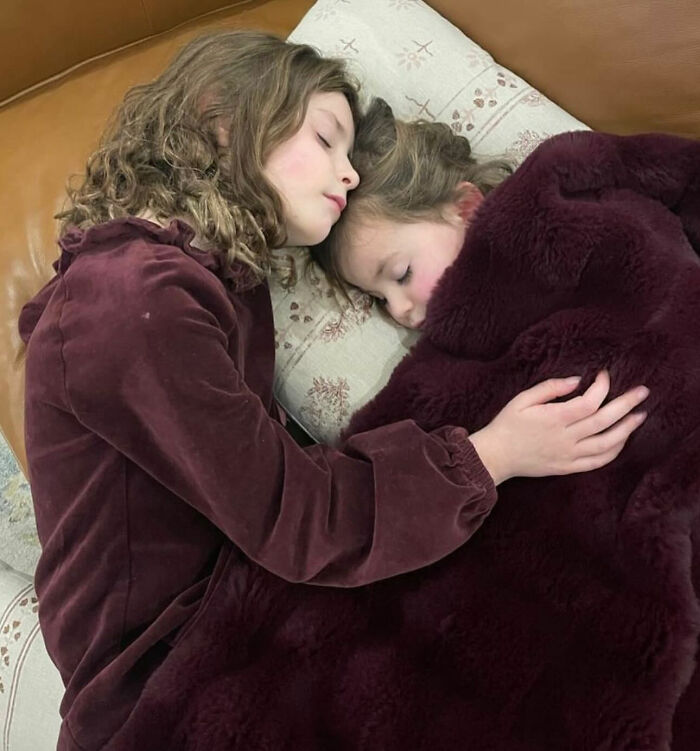 Two young girls lying close together on a couch covered with a blanket, symbolizing loss of influencer's daughter at Christmas. Two young girls lying close together on a couch covered with a blanket, symbolizing loss of influencer's daughter at Christmas.