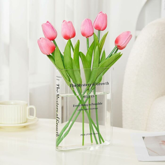 Pink tulips in a clear glass vase, ideal gift for the teacher with patience and a caffeine a*******n on a white table.