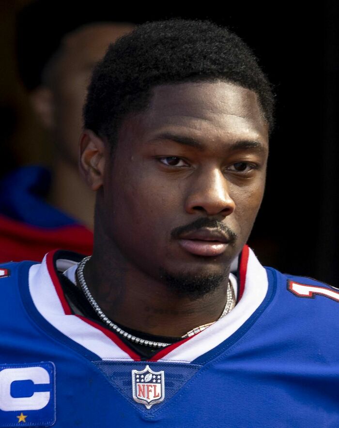 Stefon Diggs in blue NFL jersey, focused and serious, representing key moments in his bio and career highlights.