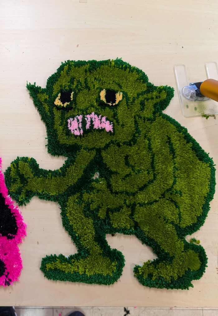 Handmade green creature rug showing cool craftsmanship and creativity in unique people-made art.