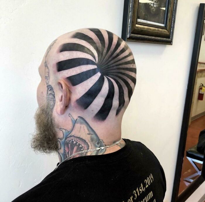 Man with optical illusion tattoo on shaved head, spiral pattern creating a confusing visual effect for the brain.