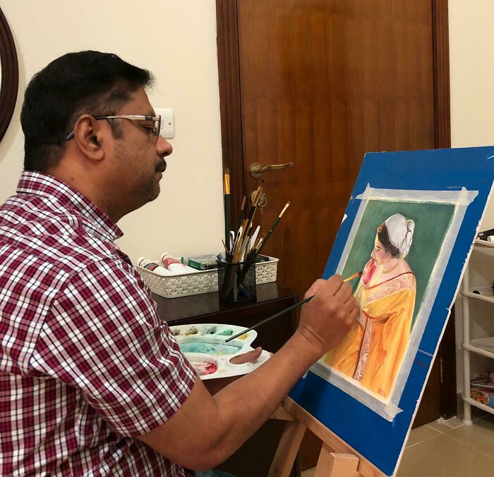 Man focused on painting a detailed portrait indoors, showcasing creativity and making a bold life decision through art.