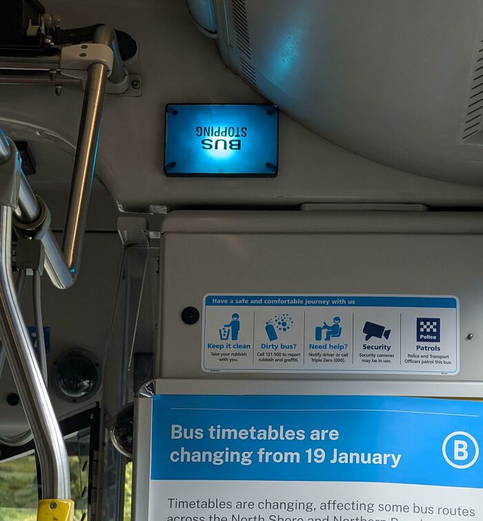 Bus interior with upside-down stop sign and timetable board showing changes starting 19 January, illustrating poor job e*******n.