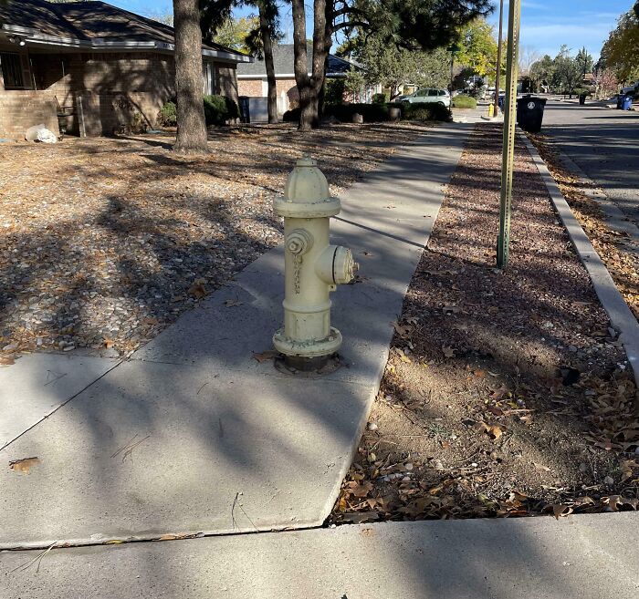 Fire hydrant poorly installed in the middle of a sidewalk, showing a job done so poorly it’s almost impressive.