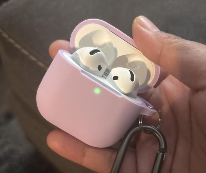 Wireless earbuds in a pink charging case held in hand, showcasing popular products on Amazon wish lists.