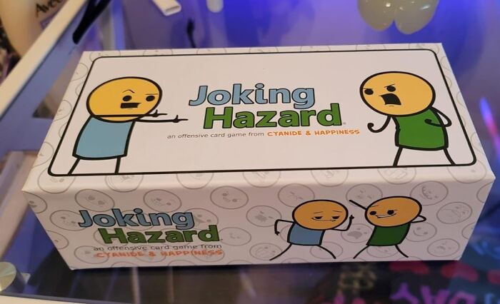 Joking Hazard card game box featuring popular products from Amazon wish lists displayed on a store shelf.