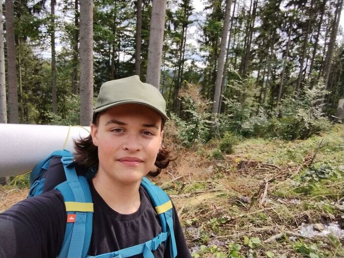 Young person with hiking gear on a forest trail, embodying the leap of faith in making life decisions.