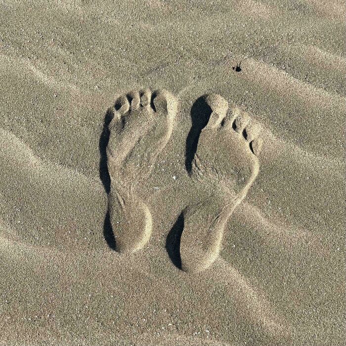 Sand imprint of feet in the sand, a confusing photo that challenges perception and might puzzle your brain.