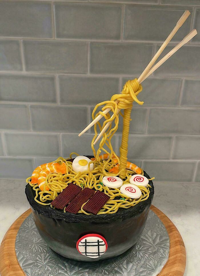 Creative cake designed as a bowl of ramen with noodles, shrimp, egg, and chopsticks showcasing masterfully crafted cakes.