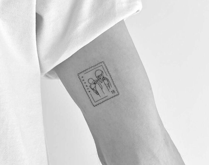Minimalist wholesome tattoo of two people inside a postage stamp design on inner arm showing meaningful ink. Minimalist wholesome tattoo of two people inside a postage stamp design on inner arm showing meaningful ink.