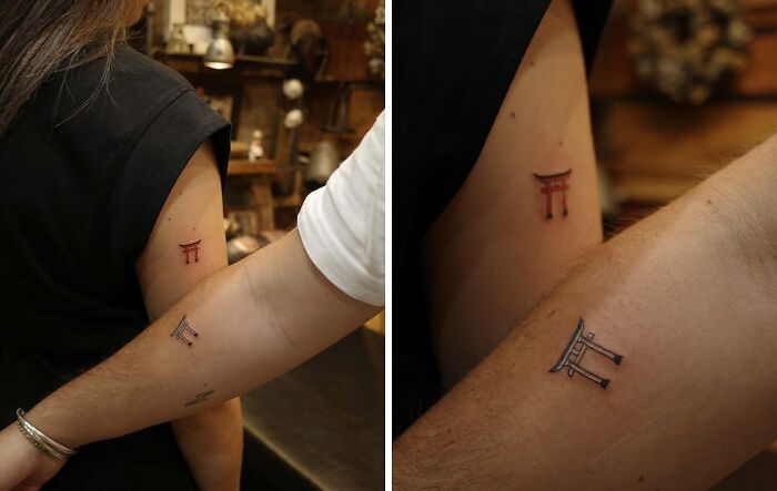 Small matching wholesome tattoos of Japanese torii gates on two arms, symbolizing meaningful connection and ink art.