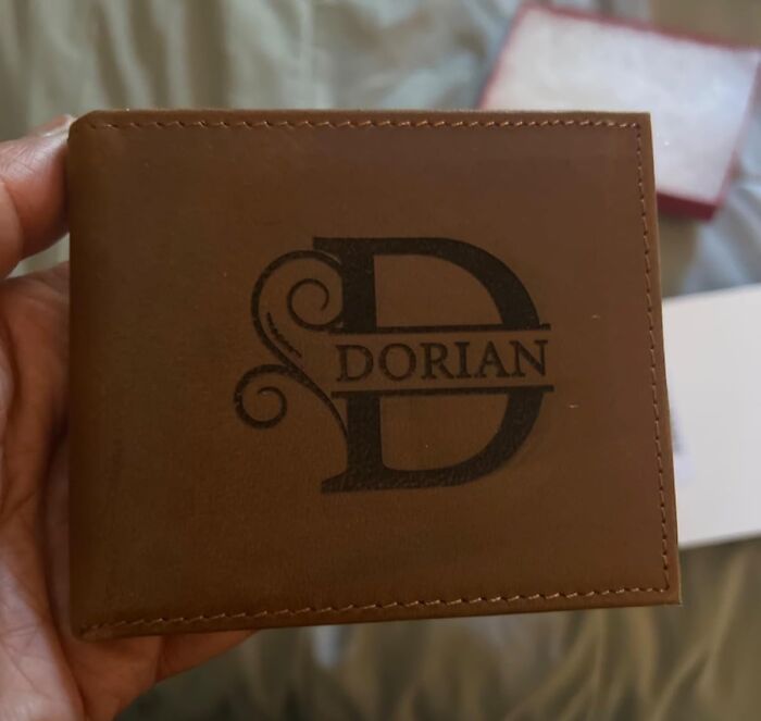 Hand holding a brown leather custom wallet with engraved name, ideal for custom gifts ready in time for Christmas.
