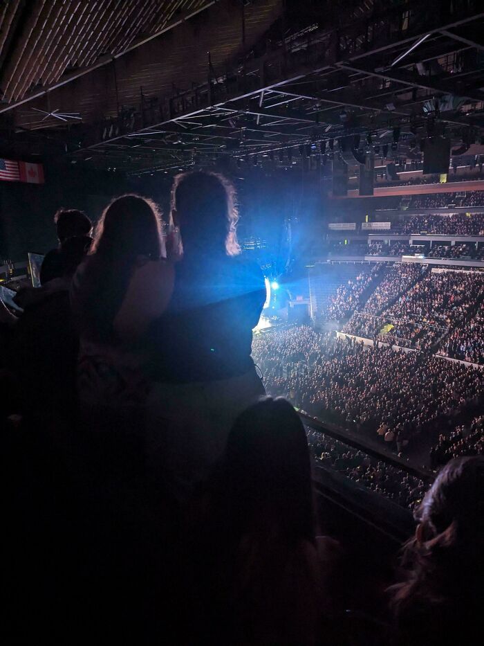 Crowd at a large indoor event with intense lighting, capturing a moment that tests calmness amid rage-inducing scenes.