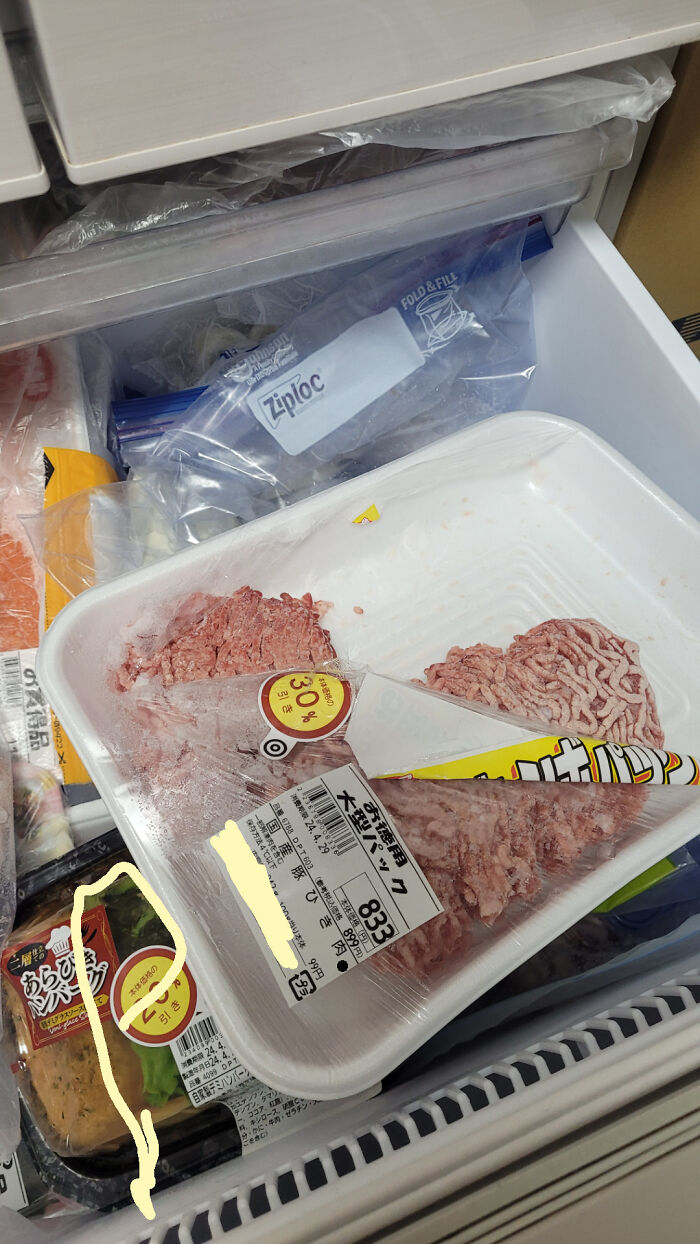Partially frozen meat in a c*****d plastic tray inside a freezer, illustrating a rage-inducing packaging fail.