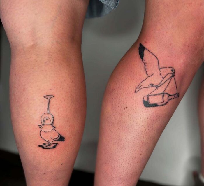 Minimalist wholesome tattoos of a bird with an upside-down glass and a bird carrying a bottle on two calves.