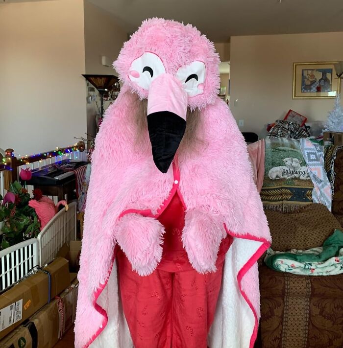 Person wearing a fluffy pink flamingo costume, a fun and quirky white elephant gift idea for holiday parties.