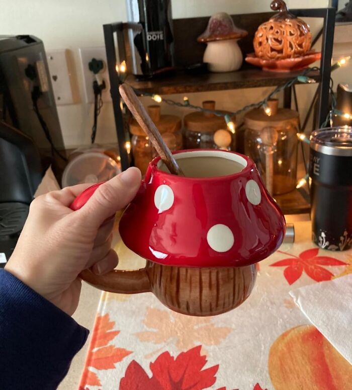 Hand holding a whimsical mushroom-shaped mug, one of the unique white elephant gifts for festive gift exchanges.