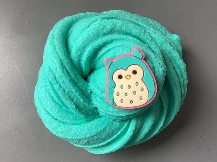 Blue fluffy slime with a cute owl charm, a popular white elephant gift idea for fun and playful exchanges.