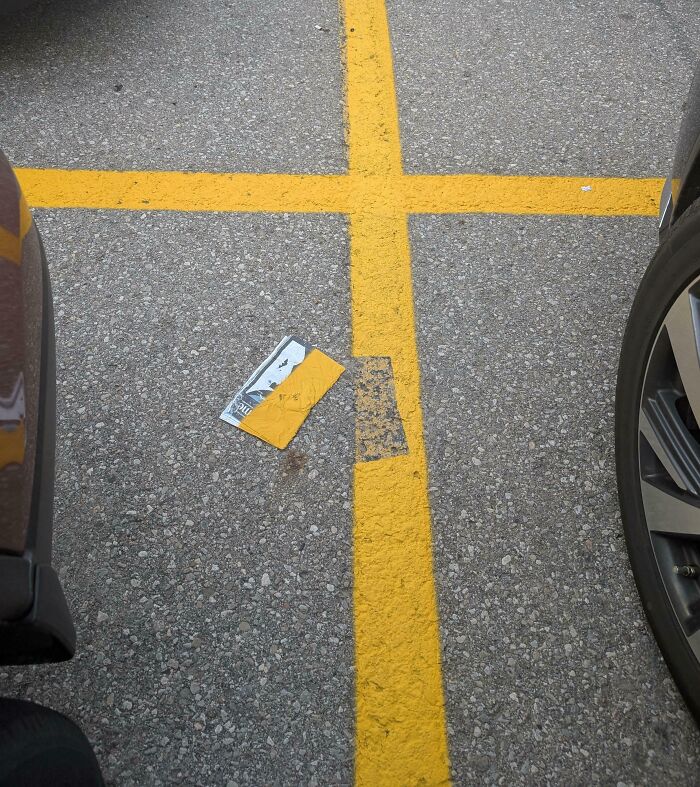 Parking lot lines painted unevenly and poorly, showing a clear example of jobs done so poorly it is almost impressive.