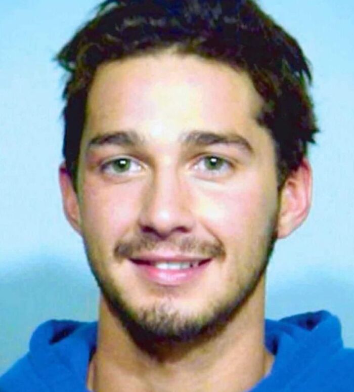 Young man smiling in a blue hoodie in an infamous celebrity mugshot related to reasons for arrest.