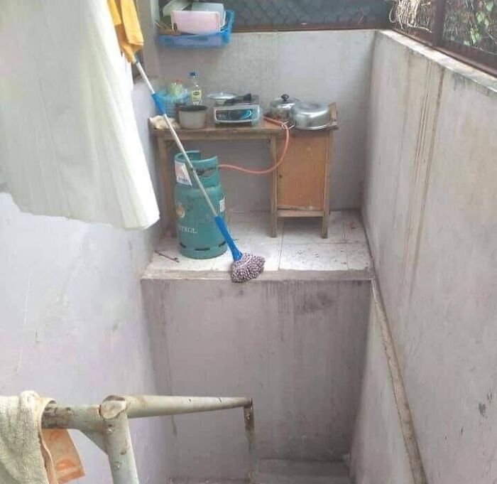 A mop precariously placed on the edge above stairs, illustrating times people did their jobs poorly almost impressively.