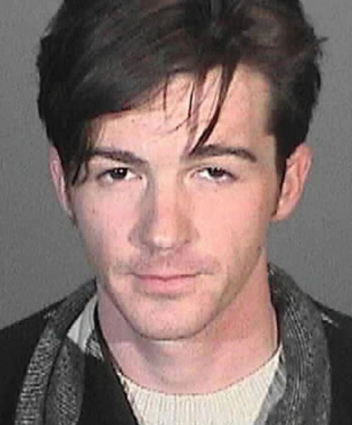 Young man in a mugshot photo, demonstrating an example of infamous celebrity mugshots and their arrest reasons.