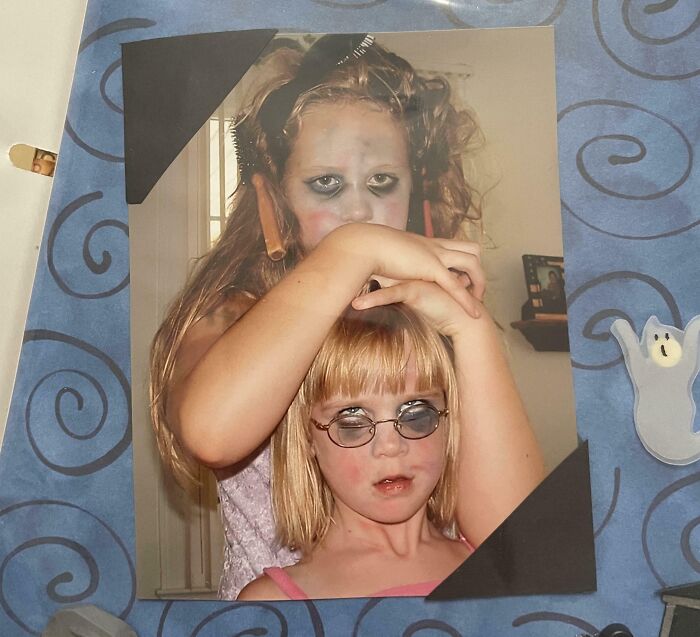 Two children with messy makeup and hair in a hilariously awkward childhood photo capturing funny moments.