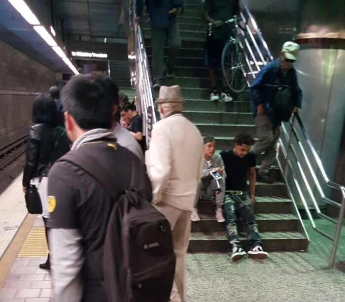 Commuters on crowded subway platform with people blocking stairs, testing patience in rage-inducing situations.