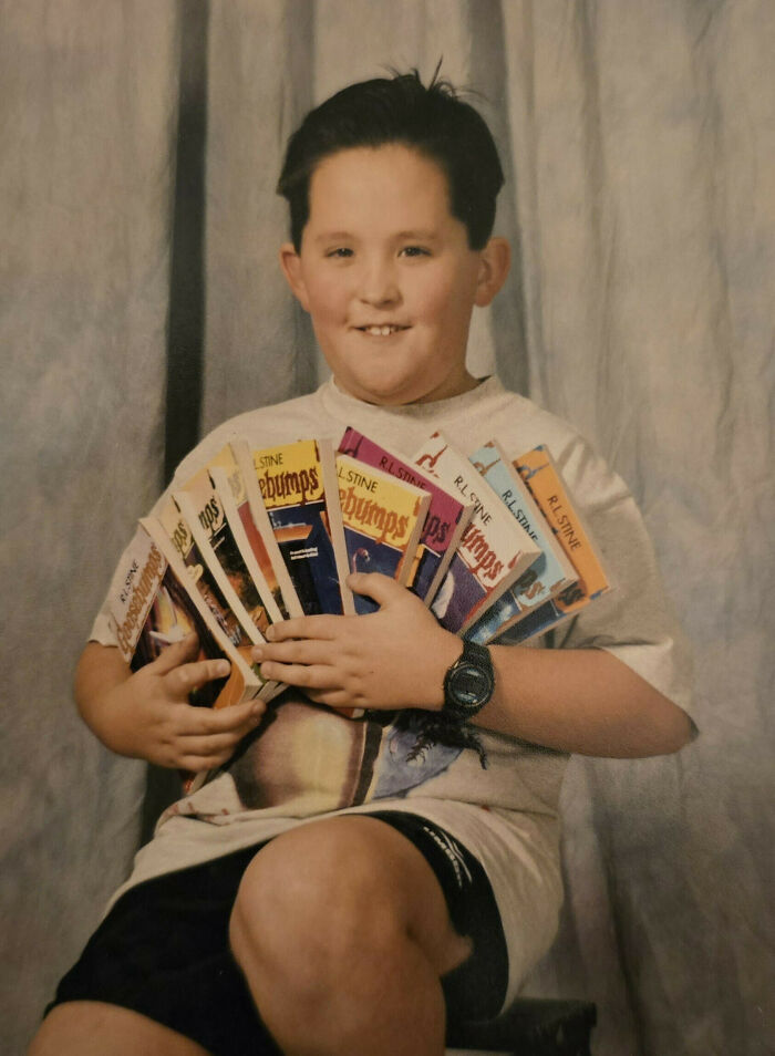 Child holding a collection of Goosebumps books, a classic example of hilariously awkward childhood photos.