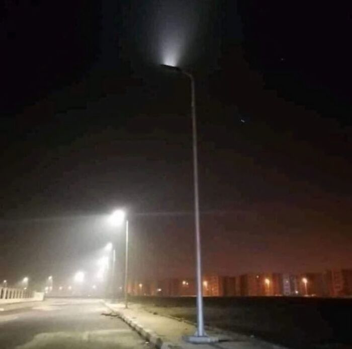 Streetlights poorly installed with one light off making it almost useless in a dark road, showing job fail in street lighting.