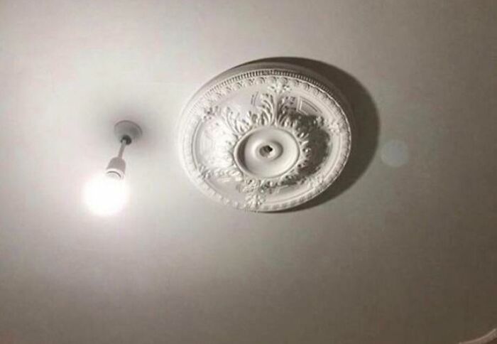 Light fixture installation fail with a bare bulb next to an unused decorative ceiling medallion, showing poor job quality. Light fixture installation fail with a bare bulb next to an unused decorative ceiling medallion, showing poor job quality.