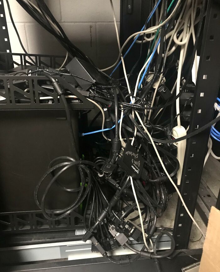 Messy tangled cables and wires in a server rack showing poor cable management by people at their jobs.